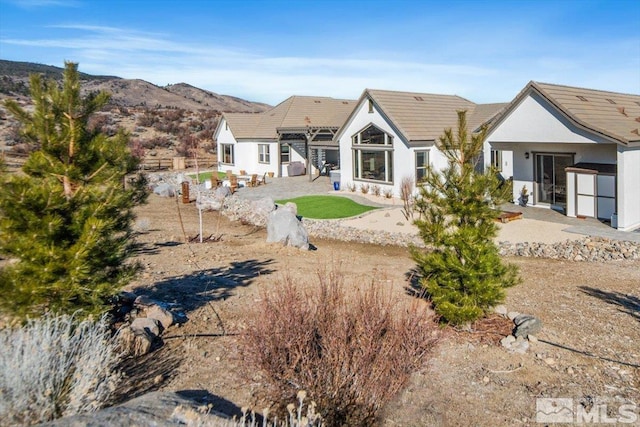 rear view of house with a patio area, a mountain view, and a pergola