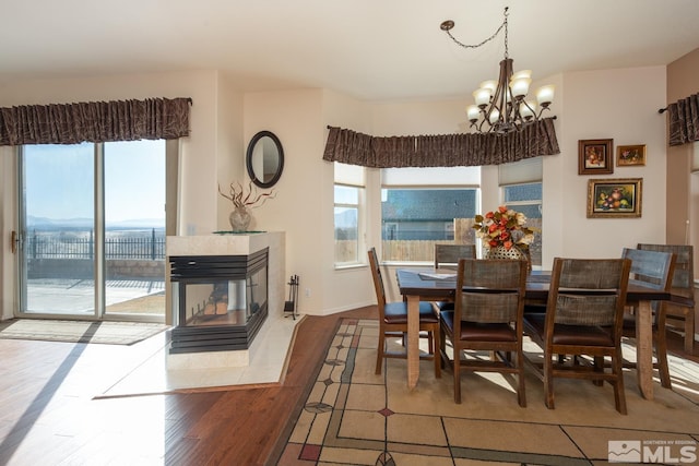 dining area featuring light hardwood / wood-style floors, a chandelier, and a fireplace