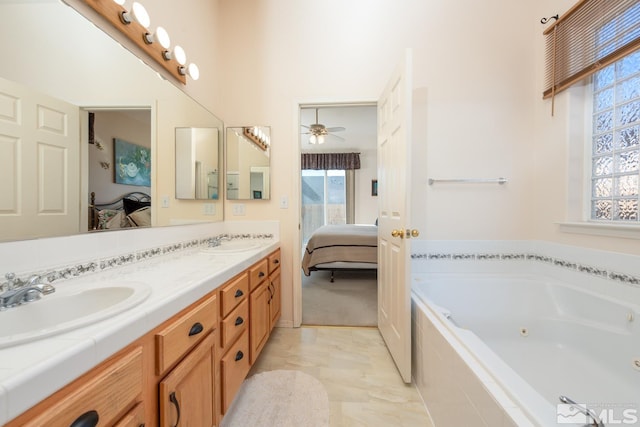 bathroom featuring vanity, tiled tub, and ceiling fan