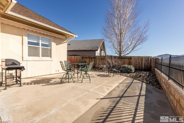 view of patio / terrace with a grill and a mountain view