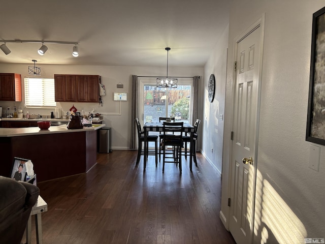 kitchen with rail lighting, a chandelier, hanging light fixtures, and dark hardwood / wood-style floors