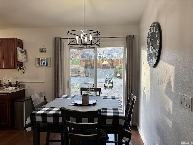 dining area featuring dark wood-type flooring and a chandelier