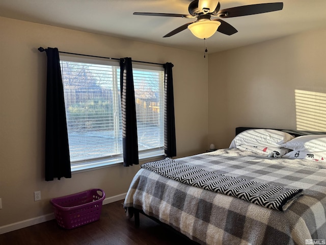 bedroom with ceiling fan, dark hardwood / wood-style flooring, and multiple windows