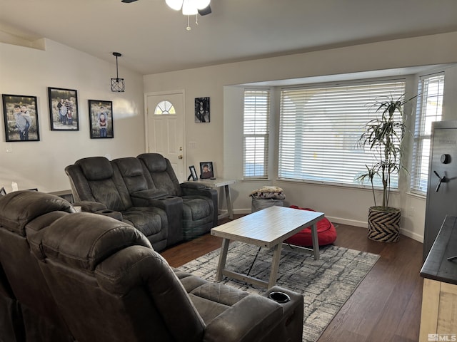 living room with lofted ceiling, dark wood-type flooring, ceiling fan, and plenty of natural light