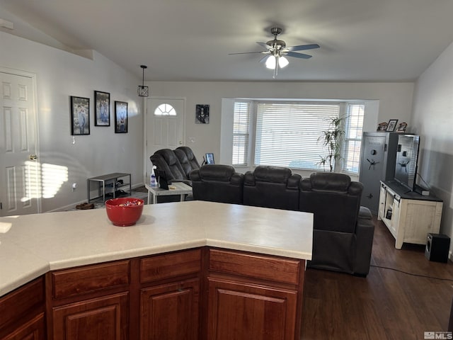 kitchen with lofted ceiling, ceiling fan, pendant lighting, and dark hardwood / wood-style floors