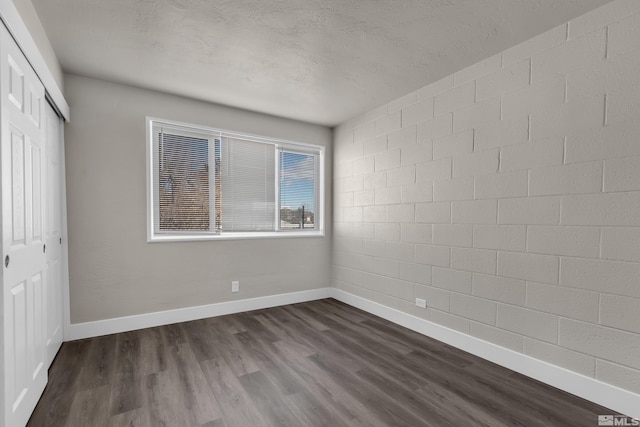 unfurnished bedroom featuring a closet and dark hardwood / wood-style flooring