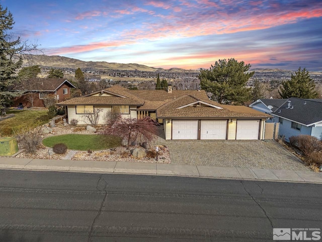 single story home featuring a mountain view and a garage