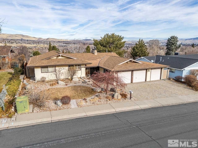 single story home featuring a garage and a mountain view