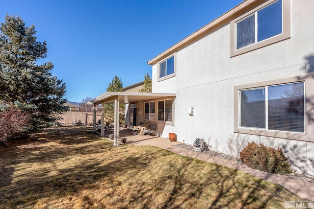 rear view of property featuring a yard and a patio area