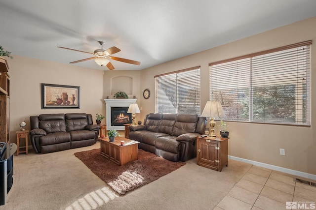 living room with ceiling fan, a fireplace, and light tile patterned floors