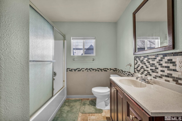 full bathroom with toilet, vanity, and shower / bath combination with glass door