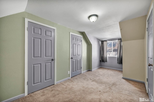 bonus room featuring vaulted ceiling and light carpet