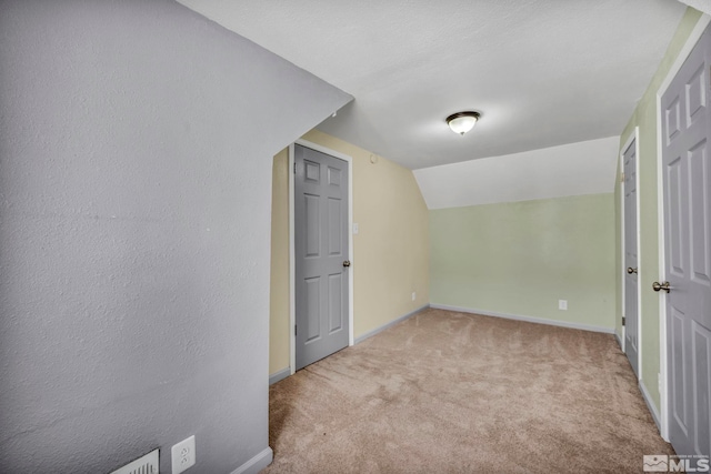 bonus room with light colored carpet and lofted ceiling