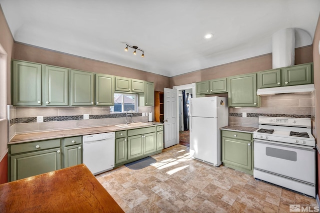 kitchen featuring white appliances, tasteful backsplash, and sink