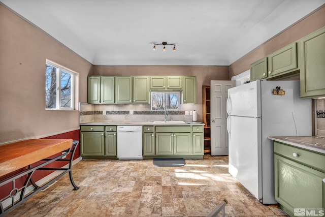 kitchen with sink, green cabinetry, white appliances, and backsplash