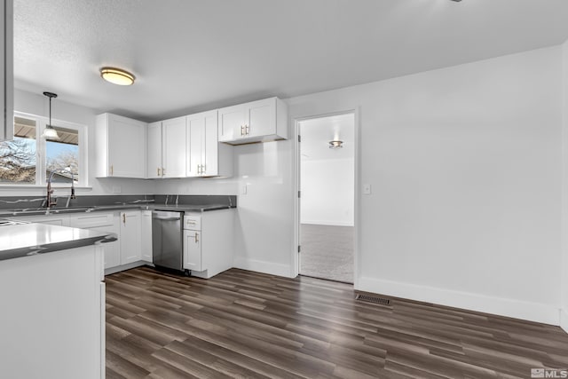 kitchen with stainless steel dishwasher, a textured ceiling, decorative light fixtures, white cabinetry, and sink