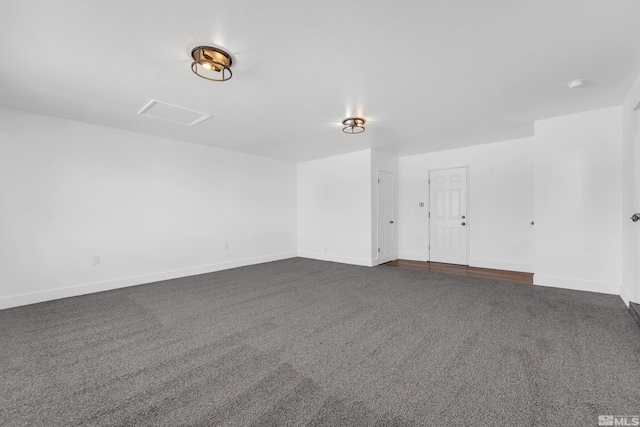 spare room featuring dark colored carpet