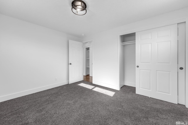 unfurnished bedroom with a closet and dark carpet