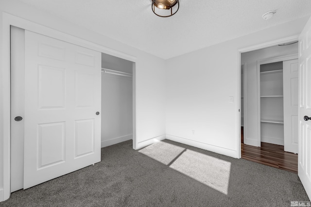 unfurnished bedroom featuring dark colored carpet and a closet