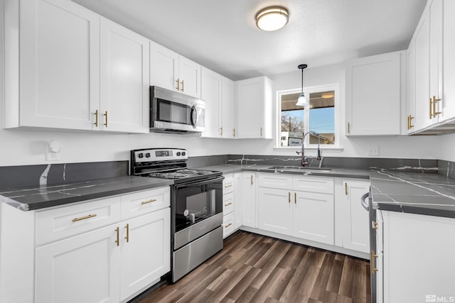 kitchen with appliances with stainless steel finishes, white cabinetry, and sink