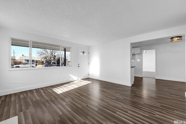 empty room featuring dark hardwood / wood-style flooring and a textured ceiling