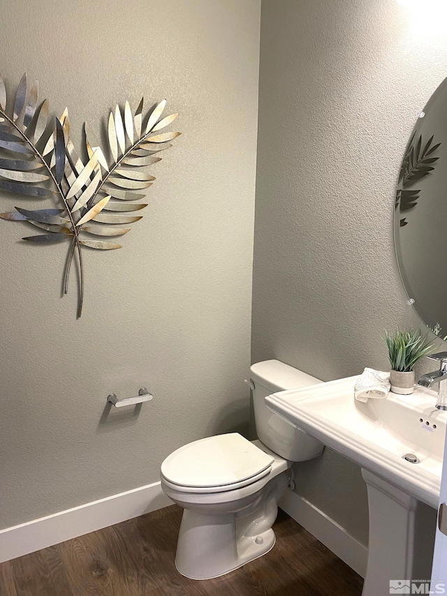 bathroom with toilet and wood-type flooring