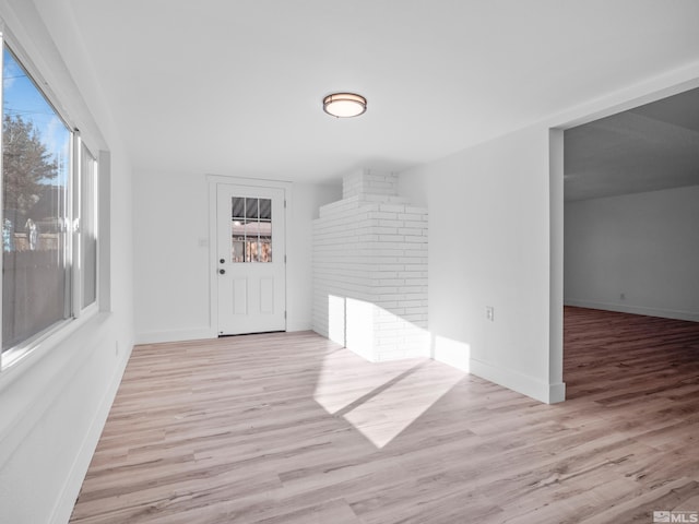 foyer with light wood-type flooring and a fireplace