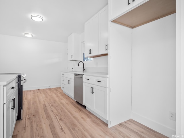 kitchen featuring appliances with stainless steel finishes, light hardwood / wood-style flooring, white cabinetry, and sink