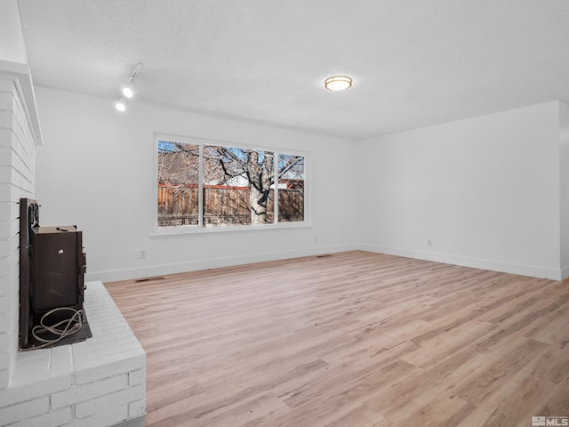 unfurnished living room with light wood-type flooring and a fireplace