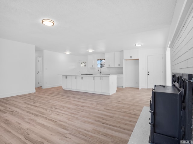 kitchen with white cabinets, light hardwood / wood-style flooring, and a textured ceiling