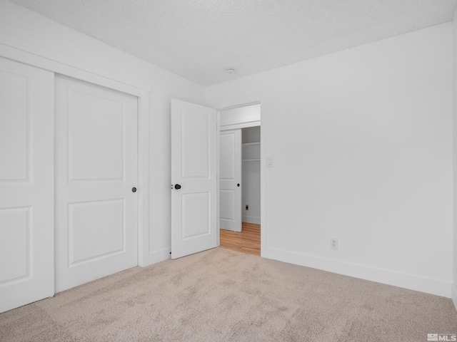 unfurnished bedroom featuring light colored carpet and a closet