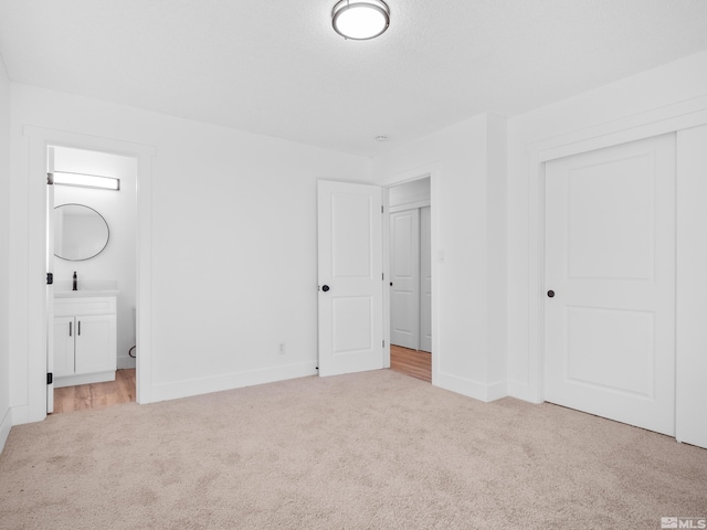 unfurnished bedroom featuring light colored carpet, connected bathroom, and a closet