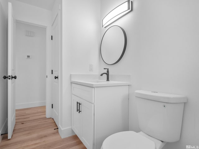 bathroom featuring hardwood / wood-style floors, vanity, and toilet