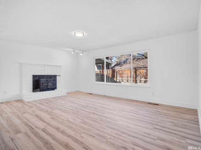 unfurnished living room with light hardwood / wood-style flooring and track lighting