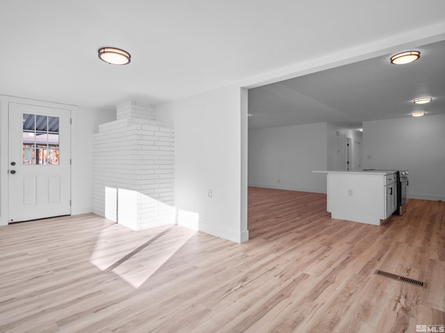 unfurnished living room featuring a fireplace and light wood-type flooring