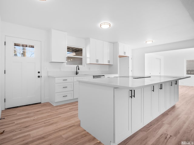 kitchen featuring a kitchen island, sink, and white cabinetry