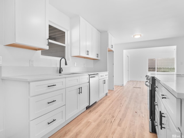 kitchen featuring sink, white cabinets, light hardwood / wood-style floors, and appliances with stainless steel finishes