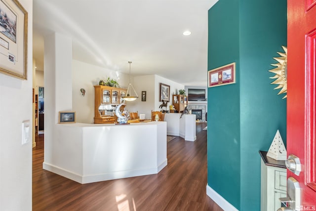 kitchen featuring a tile fireplace, pendant lighting, and dark hardwood / wood-style flooring