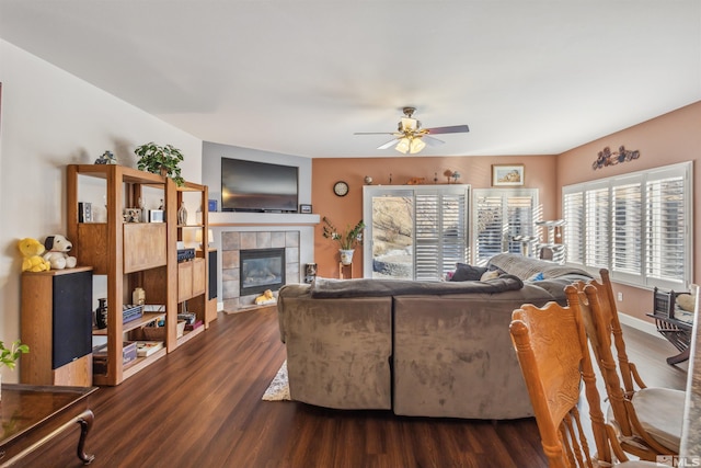 living room featuring a tile fireplace, ceiling fan, and dark hardwood / wood-style flooring