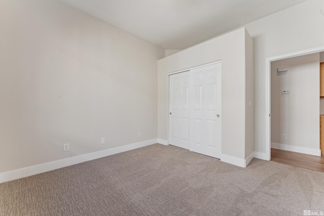 unfurnished bedroom with a closet and light carpet