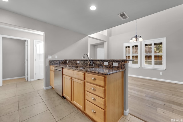 kitchen featuring sink, decorative light fixtures, kitchen peninsula, dark stone counters, and a notable chandelier