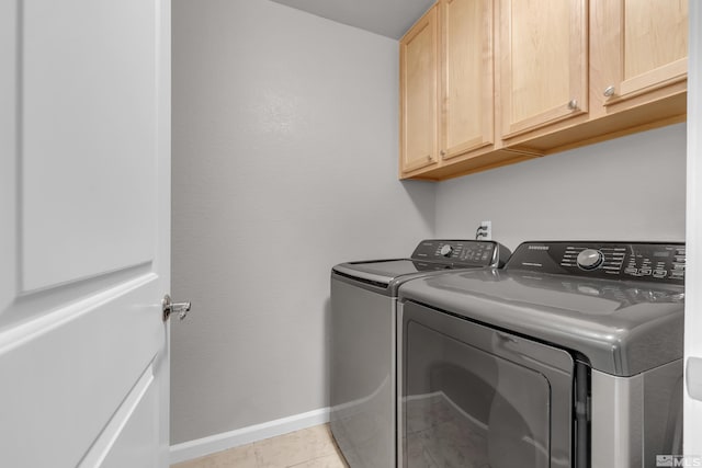 laundry room featuring cabinets, washer and clothes dryer, and light tile patterned floors