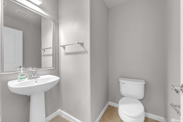 bathroom featuring toilet, tile patterned floors, and sink