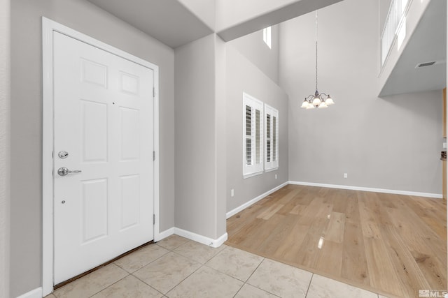 foyer featuring an inviting chandelier and light tile patterned floors