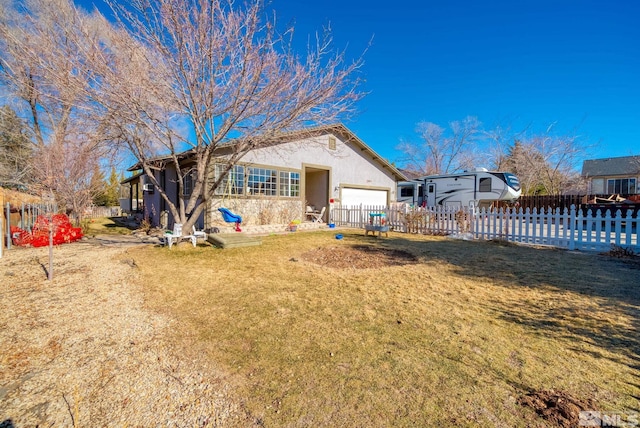 back of property with a garage and a yard