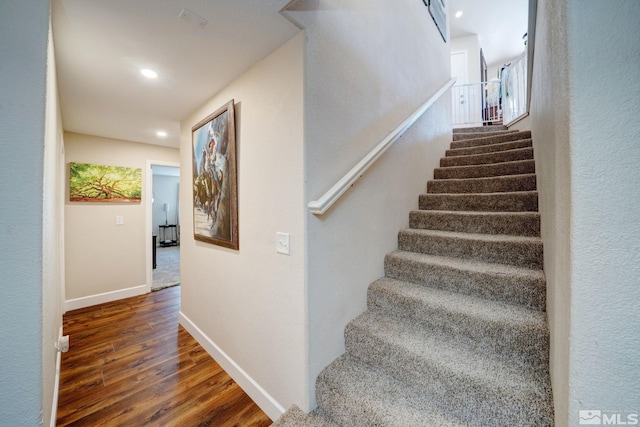 stairs featuring wood-type flooring