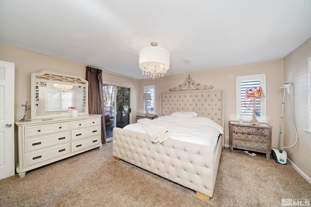 bedroom featuring light colored carpet, an inviting chandelier, and access to exterior