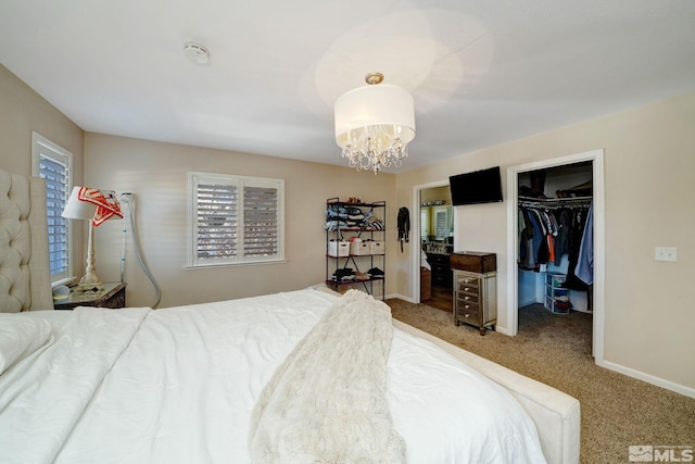 bedroom featuring a spacious closet, an inviting chandelier, a closet, and carpet flooring