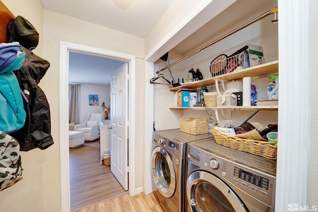 clothes washing area featuring washer and dryer and light hardwood / wood-style floors