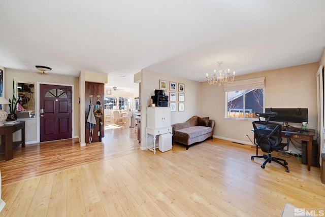 home office with light wood-type flooring, an inviting chandelier, and plenty of natural light